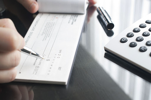 image of person writing out a check