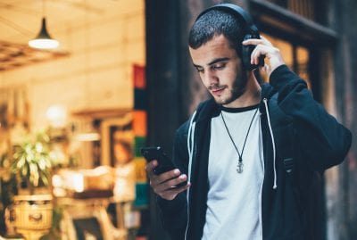 man listening to music through headphones