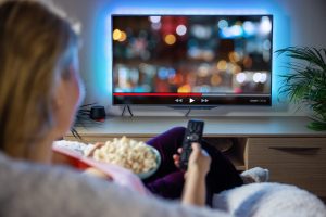 Woman relaxing at home in evening and streaming TV