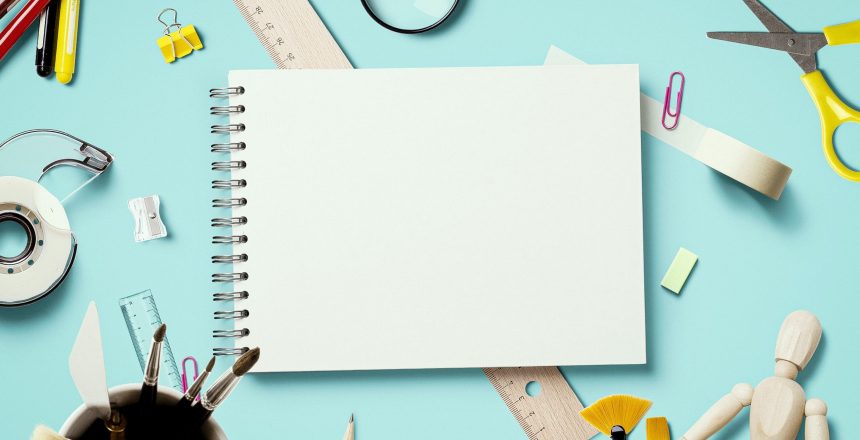 school supplies around a blank notepad