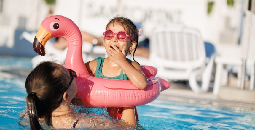 mom and daughter in pool have fun during summer vacation. Child having fun in swimming pool.