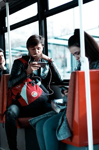 person riding bus looking at phone