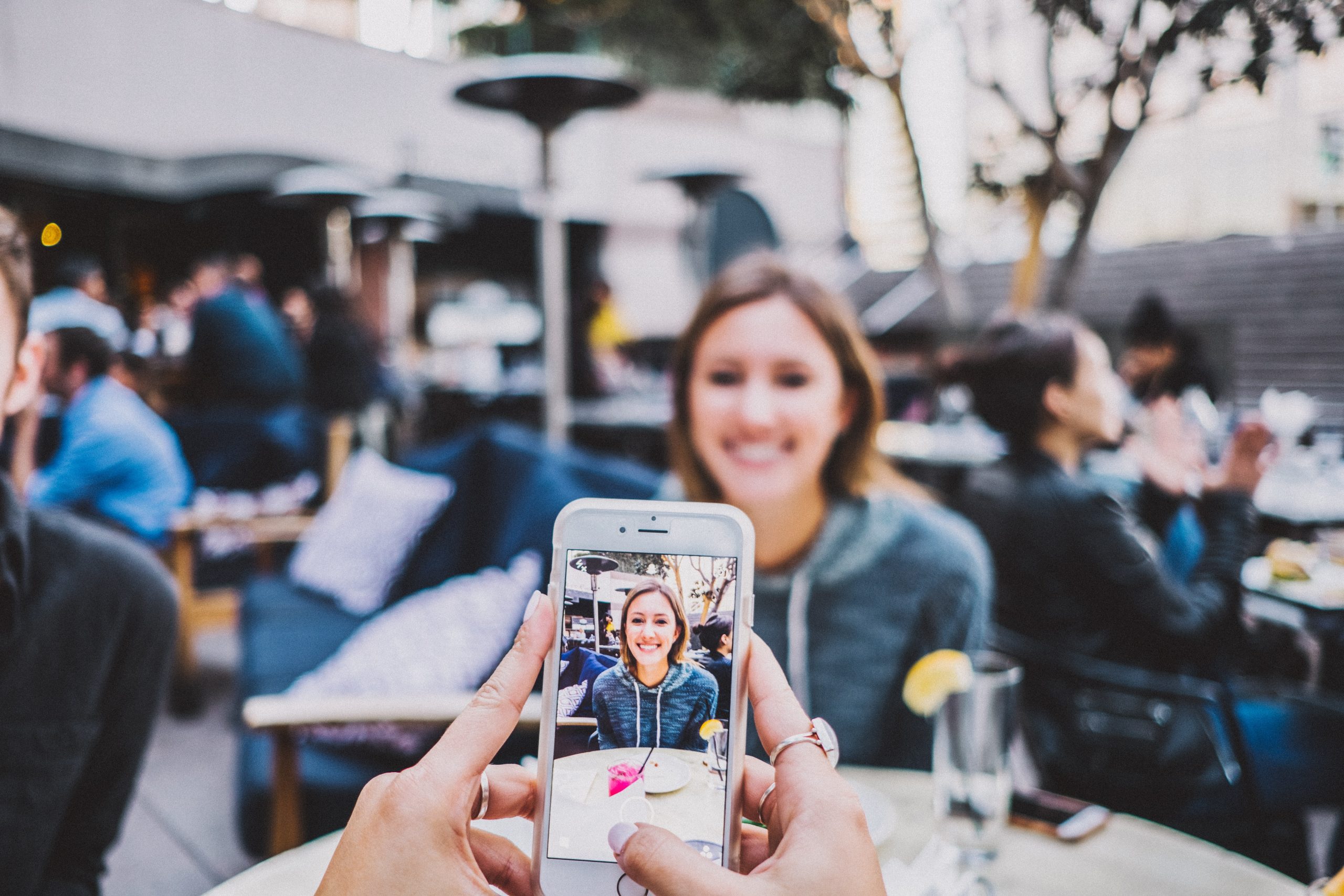 image of someone taking a photo of women at a restaurant table