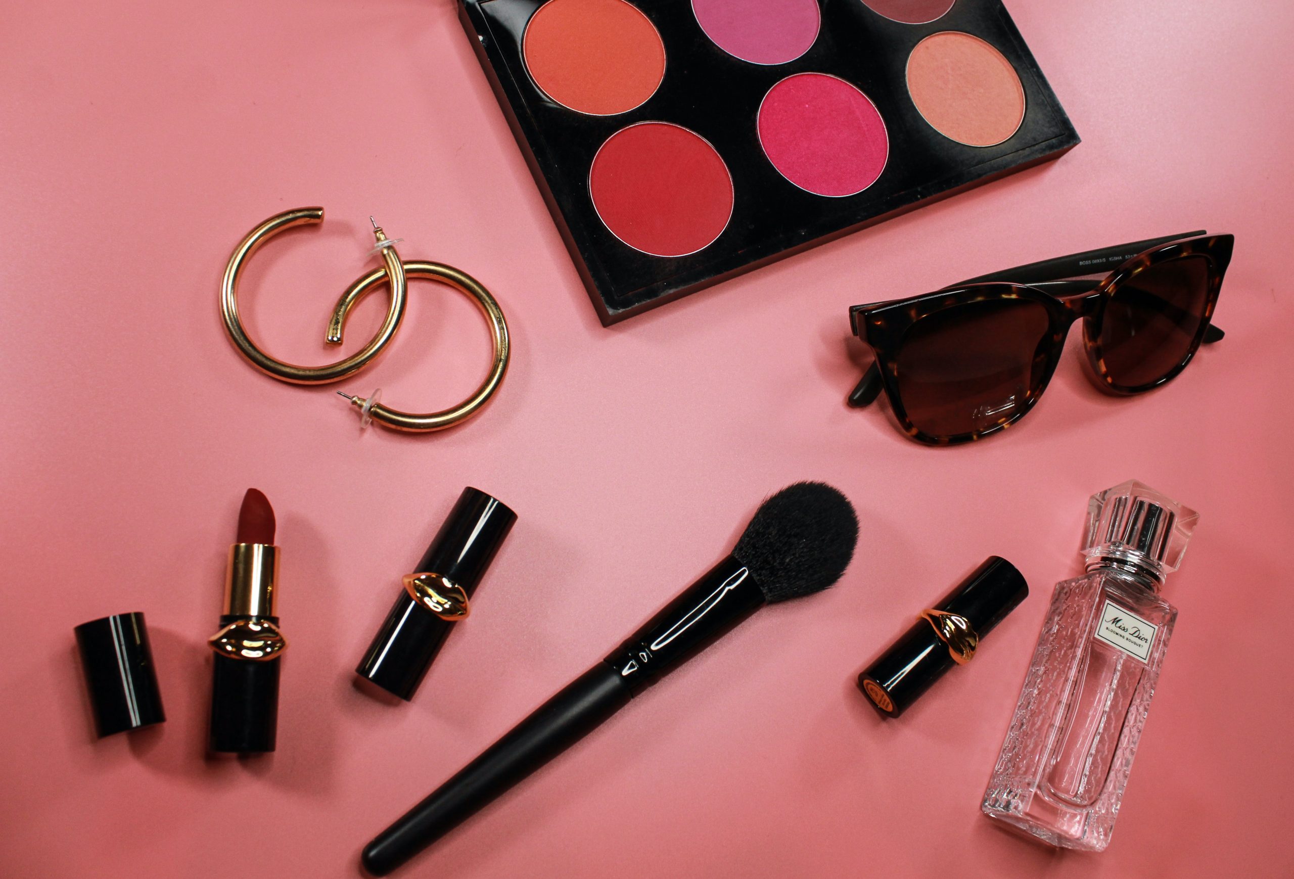 makeup palette: eyeshadow, make up brush, earrings, lipstick, sunglasses