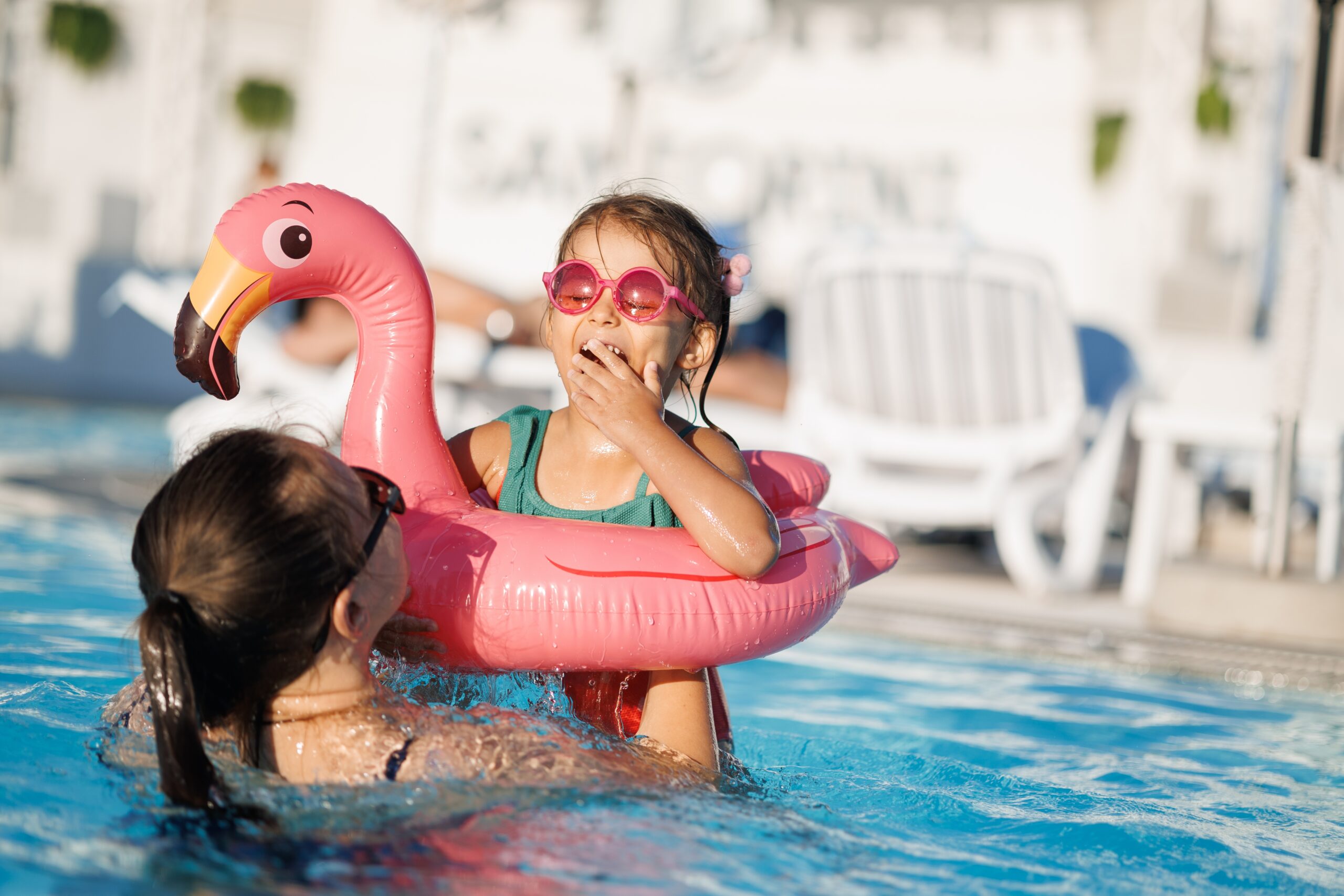 mom and daughter in pool have fun during summer vacation. Child having fun in swimming pool.